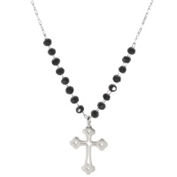 Collier composé d'une chaîne en acier argenté avec en partie des perles de couleur noire et un pendentif croix ajourée en acier  argenté. Fermoir mousqueton avec rallonge de 5 cm.