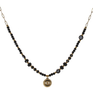 Collier composé d'une chaîne en acier doré, de perles de couleur noire, de perles rondes représentant un œil et d'un pendentif rond représentant un œil en acier doré. Fermoir mousqueton avec 5 cm de rallonge.