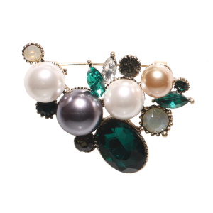 Broche en forme de feuille en métal doré surmontée de cristaux de couleur blanc, noir et vert et de perles d'imitation de couleur grise et blanche.