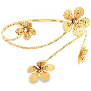 Ce bracelet de bras est une pièce qui allie poésie et modernité. Son design organique semble s'enrouler délicatement autour du haut du bras, évoquant une liane précieuse en pleine floraison. Le bracelet est orné de quatre fleurs délicates de tailles variées. Chaque pétale présente une texture martelée qui capte la lumière sous tous les angles, créant des reflets chatoyants et un aspect naturel, presque artisanal. Au cœur de chaque fleur se niche un cristal scintillant, apportant une touche de lumière pure et un contraste élégant avec l'acier doré. Ce bracelet de bras est l'accessoire idéal pour sublimer une robe de soirée sans manches, une tenue de mariée bohème ou même un look d'été plus décontracté. Il apporte instantanément une touche de grâce antique et de féminité solaire.