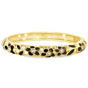 Ce bracelet de style jonc se distingue par son travail d'orfèvrerie délicat et ajouré. Il présente une alternance de motifs végétaux qui font tout son charme. Le tour du bracelet est orné de petites fleurs à cinq pétales, soigneusement travaillées. Les pétales sont remplis d'un émail noir profond, créant un contraste saisissant et moderne avec l'éclat du métal. Système de charnière discret permettant d'enfiler et de retirer le bijou avec facilité tout en assurant un maintien sécurisé au poignet.