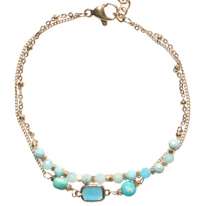 Bracelet double rangs composé d'une chaîne en acier doré avec des perles rondes de couleur bleue turquoise, ainsi qu'une chaîne en acier doré avec deux perles rondes de couleur bleue turquoise et d'un cristal bleu turquoise serti clos. Fermoir mousqueton avec 3 cm de rallonge.