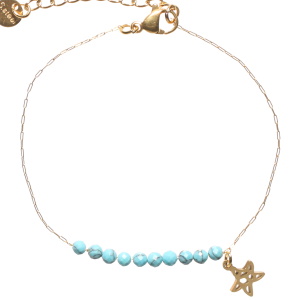 Bracelet composé d'une chaîne avec un pendant en forme d'étoile de mer et de perles de couleur bleue turquoise. Fermoir mousqueton avec 3 cm de rallonge.