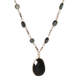 Collier sautoir fantaisie composé d'une chaîne en acier doré, de perles de couleur grise et noire et d'un pendentif de forme ovale serti d'un cristal noir. Fermoir mousqueton avec 5 cm de rallonge.