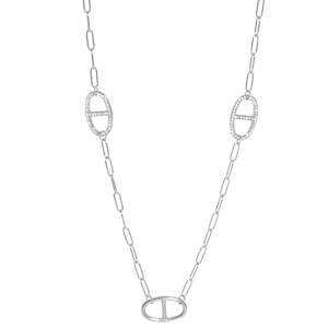 Ce collier incarne l'élégance moderne avec un design à la fois épuré et sophistiqué. Conçu en acier inoxydable de haute qualité, il offre une brillance durable et une résistance optimale au quotidien. Le collier est rythmé par cinq maillons ovales inspirés du design iconique grain de café. Pour un contraste raffiné, deux de ces motifs sont délicatement sertis de cristaux brillants, captant la lumière à chaque mouvement, tandis que les trois autres affichent un fini poli miroir lisse. Sa longueur de type sautoir permet de le porter seul pour un look minimaliste chic, ou en superposition pour un style plus audacieux.