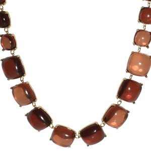 Collier composé de carrés en acier doré sertis de cristaux de couleur marron. Fermoir mousqueton en acier doré avec 5 cm de rallonge.