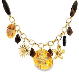 Ce collier à breloques en acier doré est une œuvre d'art bohème. Il présente une composition unique avec des détails comme un cabochon d'ambre ovale jaune translucide, des motifs gravés. Un mélange éclectique qui capture l'esprit libre et l'individualité. Idéal pour ajouter une touche d'originalité à toute tenue.