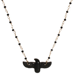 Collier composé d'une chaîne en acier doré, de perles de couleur noire et d'un pendentif en forme d'aigle de couleur noir. Fermoir mousqueton avec 5 cm de rallonge.