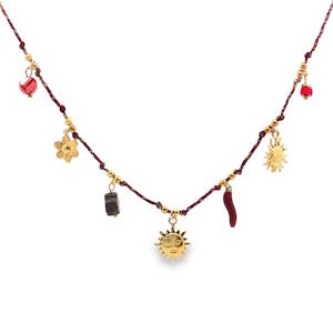 Ce collier à breloques unique en son genre marie l'artisanat traditionnel à une esthétique bohème chic. Le cordon tressé, ponctué de détails dorés délicats, sert de toile de fond à une série de breloques éclectiques. Un accessoire distinctif qui apporte une touche d'originalité à toute tenue. Fermoir mousqueton avec 5 cm de rallonge.