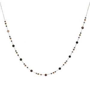 Collier composé d'une chaîne avec perles en acier doré, des perles cylindriques de couleur noire et des perles rondes de couleur noire. Fermoir mousqueton avec 5 cm de rallonge.