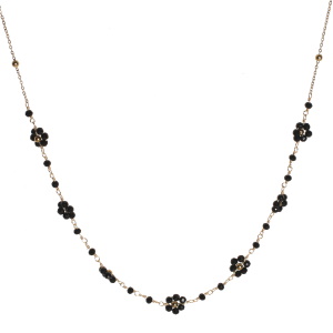 Collier composé d'une chaîne en acier doré et de fleurs en perles de couleur noire. Fermoir mousqueton avec 5 cm de rallonge.