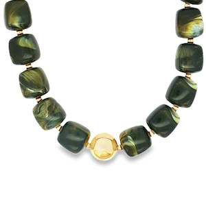 Ce collier de perles, façonné à partir de matériaux non métalliques, arbore des nuances complexes de vert, rehaussées par des détails dorés. Les perles, taillées en formes carrées, s'enchaînent avec élégance, créant un bijou à la fois moderne et intemporel. Fermoir mousqueton avec 5 cm de rallonge.