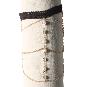 Bracelet de bras composé d'un cordon de couleur noir et de chaîne en métal doré avec des perles d'imitation. Fermoir mousqueton avec 7 cm de rallonge.