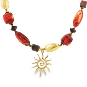 Ce collier de perles artisanales, ponctué de notes dorées et de teintes chaudes, est un hommage à l'éclat solaire. Le pendentif doré, évoquant un soleil stylisé, apporte une touche d'originalité et de lumière à ce bijou unique. Parfait pour rehausser votre style avec une élégance bohème.
