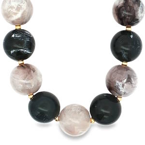 Ce collier de perles fantaisie est un accessoire de mode audacieux. Confectionné avec des perles non métalliques aux teintes contrastées et monté avec des éléments dorés, il offre un style unique et sophistiqué. Son design saisissant en fait un bijou idéal pour rehausser une tenue.