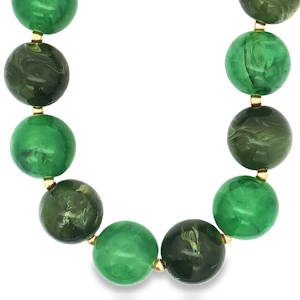 Ce collier de perles vertes, avec ses nuances profondes et son poli soigné, est un hommage à la nature. Chaque sphère, taillée en cabochon, révèle une transparence translucide et une symétrie harmonieuse, rehaussée par des accents dorés. Un bijou qui apporte une touche d'élégance naturelle à toute tenue.
