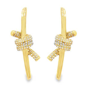 Apportez une touche de sophistication moderne et d'originalité à votre style avec cette magnifique paire de boucles d'oreilles. Alliant la robustesse de l'acier à la finesse de la haute bijouterie, ce modèle se distingue par son design contemporain et audacieux. Une structure longiligne et épurée en forme de tige verticale, sublimée en son centre par un motif de nœud en relief. Un superbe jeu de symétrie miroir entre la boucle gauche et la boucle droite vient parfaire l'équilibre visuel. Le nœud central ainsi que les extrémités du ruban sont entièrement pavés de petits cristaux scintillants (strass blancs), créant un contraste lumineux saisissant avec le métal lisse.