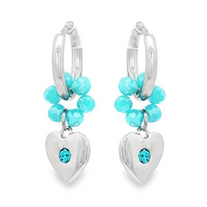 Ces élégantes boucles d'oreilles créoles en acier argenté arborent un design de cœur suspendu. Chaque boucle est ornée d'une série de perles rondes d'un bleu turquoise éclatant, soigneusement sélectionnées pour leur polissage lisse et leur couleur homogène. Chaque coeur est serti d'un cristal bleu turquoise éttincelant. Une composition artisanale sophistiquée, idéale pour ajouter une touche de couleur naturelle et d'élégance intemporelle à votre allure.