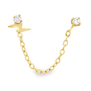 Apportez une touche de dynamisme et de modernité à votre style avec cette boucle d'oreille double piercing, conçue pour relier deux trous de perçage sur la même oreille. L'une des puces arbore un motif éclair en acier poli, symbole de force et d'énergie, surmonté d'un petit cristal scintillant. La seconde puce est ornée d'un cristal rond serti de quatre griffes, offrant une brillance pure et classique. Les deux éléments sont reliés par une fine chaîne à maillons forçat, créant un drapé délicat le long du lobe ou du cartilage. Entièrement réalisée en acier inoxydable, garantissant une haute résistance au ternissement et une excellente tolérance cutanée.