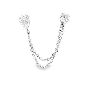 Cette pièce sophistiquée revisite le concept du piercing multiple avec une touche de haute joaillerie. Conçue pour relier deux perforations du lobe ou du cartilage (hélix), elle allie éclat classique et design contemporain. L'ensemble se compose de deux puces distinctes reliées par un jeu de chaînes pendantes et chacune sertie d'un cristal de taille poire (en forme de goutte), apportant une touche de finesse et d'allongement. Et d'un cristal de taille brillante (rond), offrant un éclat maximal et une structure équilibrée.