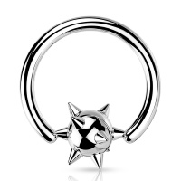 Piercing anneau avec une balle surmontée de piques en acier argenté.