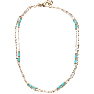 Bracelet chaîne de cheville double rangs composé d'une chaîne en acier doré et d'une chaîne en acier doré avec des perles cylindriques bleues. Fermoir mousqueton avec 5 cm de rallonge.