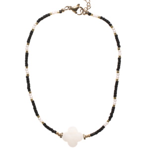 Bracelet chaîne de cheville composé de perles en acier doré, de perles d'imitation, de perles miyuki de couleur noire et d'un trèfle à quatre feuilles en nacre. Fermoir mousqueton en acier doré avec 3 cm de rallonge.