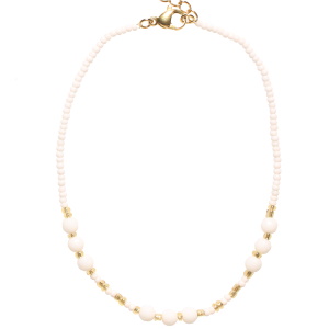 Bracelet chaîne de cheville composé de perles en acier doré, de perles de couleur blanche et des perles de cristal blanc. Fermoir mousqueton en acier doré avec 3 cm de rallonge.
