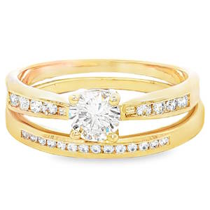 Sublimez votre main avec cet ensemble raffiné composé de deux bagues assorties, conçues pour s'emboîter parfaitement. Alliant tradition et modernité, ces bijoux en plaqué or jaune 18 carats offrent l'éclat luxueux de l'or avec une finition polie miroir. Au centre trône un magnifique oxyde de zirconium de taille ronde, maintenu par quatre griffes robustes qui maximisent la réflexion de la lumière. Les épaules de la bague sont délicatement serties de pierres plus petites pour un effet scintillant continu. Une bague demi-jonc élégante, incrustée d'une rangée de cristaux étincelants en serti rail, venant souligner et compléter parfaitement le solitaire. Ces bagues peuvent être portées ensemble pour un effet bridal set majestueux, ou séparément pour une élégance plus discrète au quotidien.