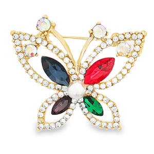 Sublime broche papillon en métal doré, ornée de pierres scintillantes multicolores et d'une perle centrale cabochon. Ce bijou délicat apportera une touche de fantaisie et d'élégance à vos tenues. Un accessoire raffiné pour sublimer votre style.