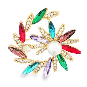 Cette broche éclatante, confectionnée à partir de métaux divers dorés, présente une magnifique perle ronde taillée en cabochon, symbole d'élégance. Un halo de gemmes colorées, disposées en forme de fleur et de couronne, rehausse son charme unique. Un accessoire parfait pour ajouter une touche de raffinement à votre tenue.