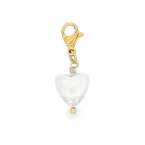 Sublime pendentif charm cœur, façonné avec une perle délicate et monté sur un apprêt en acier doré jaune éclatant. Son design épuré en fait un bijou idéal pour ajouter une touche de romantisme à votre style. Un accessoire intemporel pour sublimer votre décolleté avec élégance et raffinement.