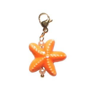 Breloque charm's en acier doré avec une étoile de mer orange et deux perles oranges. Concevez vos propres bijoux grâce à nos charm's. Ajoutez-les à vos bracelets ou colliers et apportez votre propre style et votre touche personnelle à vos bijoux.