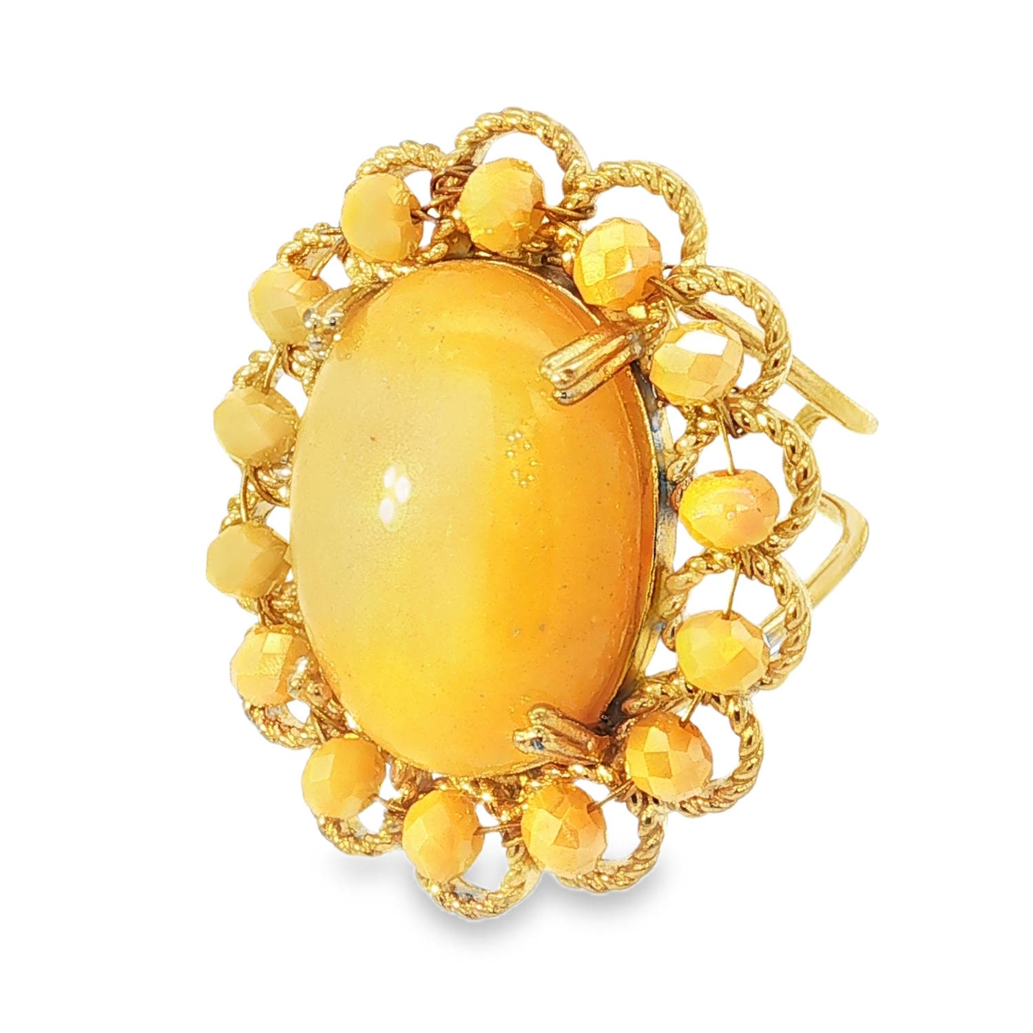Cette bague imposante, de style cocktail, se distingue par son allure rétro et sa couleur jaune miel chaleureuse. Bien que son apparence évoque l'or classique, sa conception moderne en acier inoxydable doré lui assure une grande résistance et une brillance durable.<br/>Au cœur de la bague trône un imposant cabochon ovale. Sa surface lisse et bombée présente une finition opaline d'un jaune tournesol doux. Sa texture semble imiter des matières organiques comme la résine vintage ou la pierre dure polie, captant la lumière de manière diffuse pour un éclat velouté.<br/>Le cabochon est maintenu par des griffes discrètes et entouré d'une corolle spectaculaire. Cette bordure est composée de filigranes d'acier torsadés formant une succession d'arches délicates. Chaque arche accueille une petite perle facettée de la même teinte que la pierre centrale, créant un jeu de textures entre le lisse du centre et le scintillement des facettes périphériques.<br/>Sa structure ajustable permet de l'adapter facilement à toutes les morphologies de doigts. Ovale Perle Adolescent Adulte Eté Femme Fille Printemps Cette bague imposante, de style cocktail, se distingue par son allure rétro et sa couleur jaune miel chaleureuse. Bien que son apparence évoque l'or classique, sa conception moderne en acier inoxydable doré lui assure une grande résistance et une brillance durable.<br/>Au cœur de la bague trône un imposant cabochon ovale. Sa surface lisse et bombée présente une finition opaline d'un jaune tournesol doux. Sa texture semble imiter des matières organiques comme la résine vintage ou la pierre dure polie, captant la lumière de manière diffuse pour un éclat velouté.<br/>Le cabochon est maintenu par des griffes discrètes et entouré d'une corolle spectaculaire. Cette bordure est composée de filigranes d'acier torsadés formant une succession d'arches délicates. Chaque arche accueille une petite perle facettée de la même teinte que la pierre centrale, créant un jeu de textures entre le lisse du centre et le scintillement des facettes périphériques.<br/>Sa structure ajustable permet de l'adapter facilement à toutes les morphologies de doigts. Ovale Perle Adolescent Adulte Eté Femme Fille Printemps