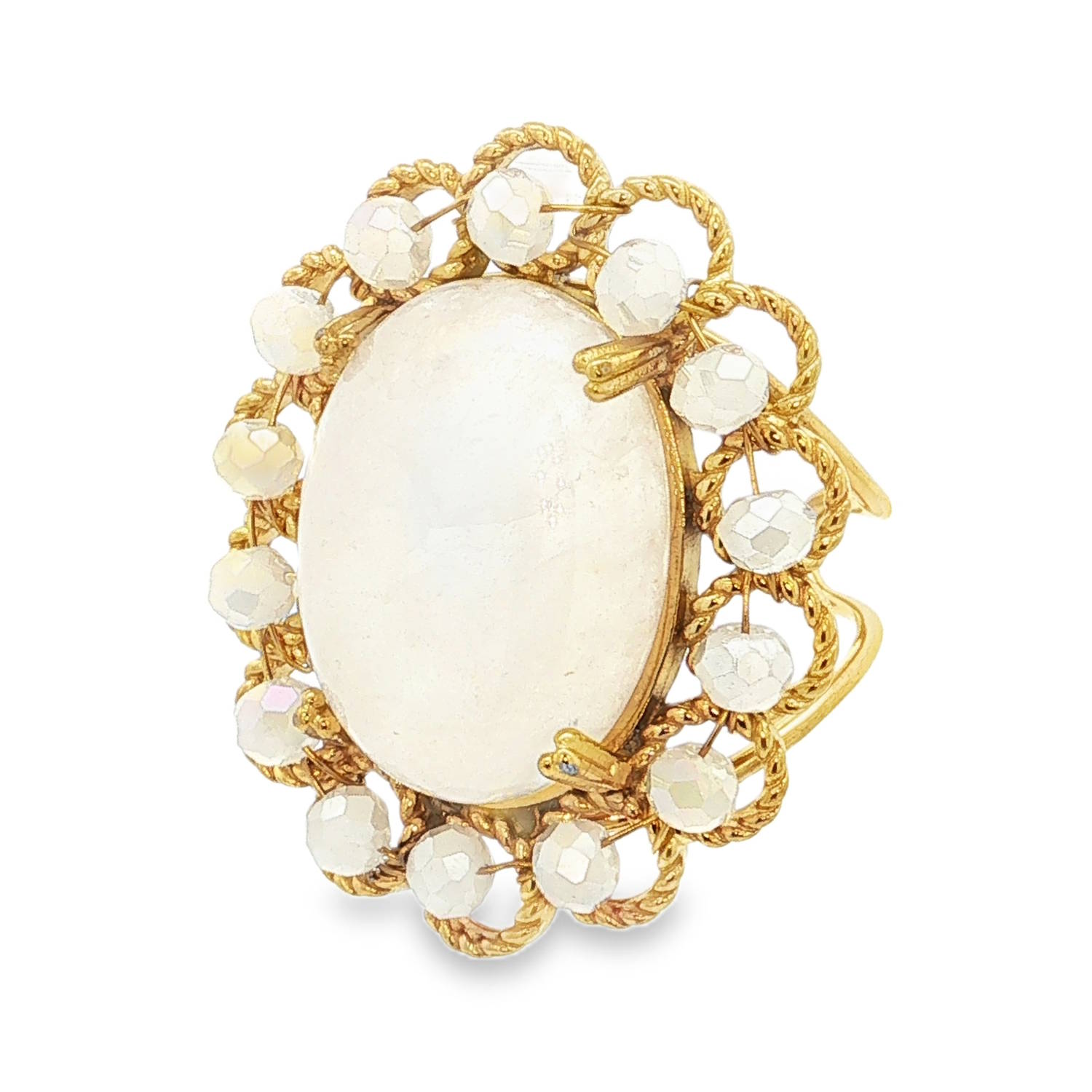 Cette bague majestueuse combine le charme de l'ancien avec la robustesse de l'acier moderne. Conçue comme un véritable bijou de caractère, elle se distingue par son design floral et ses teintes poudrées.<br/>La bague est centrée autour d'un grand cabochon ovale de couleur blanc nacré ou opalescent, rappelant l'aspect de la pierre de lune. Cette pièce centrale est entourée d'un sertissage complexe en acier doré travaillé.<br/>Chaque boucle de cette structure torsadée est agrémentée d'une petite perle aux multiples facettes avec des reflets irisés, apportant de l'éclat et du relief à l'ensemble.<br/>Sa structure ajustable permet de l'adapter facilement à toutes les morphologies de doigts. Ovale Perle Adolescent Adulte Eté Femme Fille Printemps Cette bague majestueuse combine le charme de l'ancien avec la robustesse de l'acier moderne. Conçue comme un véritable bijou de caractère, elle se distingue par son design floral et ses teintes poudrées.<br/>La bague est centrée autour d'un grand cabochon ovale de couleur blanc nacré ou opalescent, rappelant l'aspect de la pierre de lune. Cette pièce centrale est entourée d'un sertissage complexe en acier doré travaillé.<br/>Chaque boucle de cette structure torsadée est agrémentée d'une petite perle aux multiples facettes avec des reflets irisés, apportant de l'éclat et du relief à l'ensemble.<br/>Sa structure ajustable permet de l'adapter facilement à toutes les morphologies de doigts. Ovale Perle Adolescent Adulte Eté Femme Fille Printemps