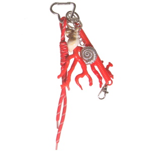 Porte-clés fantaisie avec des franges en textile rouge, d'algues rouges, de deux coquillages et d'un coquillage escargot en métal argenté.