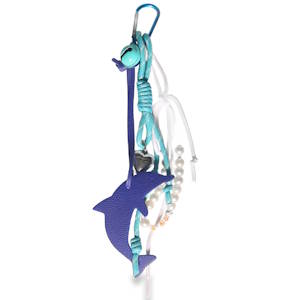 Ce porte-clés affiche un style éclectique et coloré, mélangeant plusieurs matières et breloques pour un effet pêle-mêle très visuel. Un grand dauphin similicuir de couleur violette, suspendu verticalement. La texture du cuir est légèrement grainée.