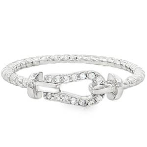 La bague se distingue par son motif central en forme de maillon marin ou d'étrier, un symbole de force et de connexion. Le corps de la bague en argent 925/000 présente une texture travaillée, rappelant l'aspect d'un cordage torsadé, apportant une touche de relief et de caractère à l'ensemble. Le maillon central est délicatement pavé de petits cristaux transparents (oxydes de zirconium), soigneusement disposés pour capturer la lumière à chaque mouvement.