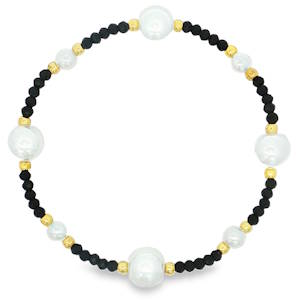 Ce bracelet élastique de perles, de type bracelet perlé, arbore un design unique où l'éclat nacré des perles rondes de style cabochon rencontre la richesse du ton doré. Un accessoire délicat et raffiné, idéal pour ajouter une touche d'élégance discrète à toute tenue.