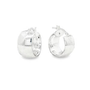 Cette paire de boucles d'oreilles se distingue par son design robuste et audacieux. Conçues dans un esprit huggie large, elles offrent une présence visuelle forte tout en restant élégantes. Ces créoles de type anneaux larges avec une forme bombée et généreuse sont en argent 925/000 offrant une brillance blanche et pure.