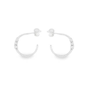 Apportez une touche d'élégance discrète à votre style quotidien avec ces créoles en argent 925/000. Conçues pour celles qui recherchent un bijou à la fois moderne et intemporel, elles se distinguent par leur finesse et leur éclat naturel. Le corps de l'anneau est orné de petites billes d'argent ciselées, créant un relief subtil qui accroche la lumière à chaque mouvement.