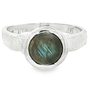 Laissez-vous envoûter par le charme authentique et mystérieux de cette bague artisanale conçue en argent massif. Alliant la force brute du métal à la magie des minéraux, ce bijou unique est une véritable invitation à l'évasion. Au centre, une superbe labradorite taillée en cabochon rond attire tous les regards. Sa base sombre révèle, au moindre mouvement et selon la lumière, des reflets irisés d'un bleu-vert fascinant (effet de labradorescence), rappelant les nuances d'une aurore boréale.